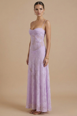 Model in a formal floral maxi dress with soft flowing movement on a plain bac