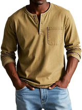 Man wearing a beige long-sleeve henley shirt and blue jeans on a white background