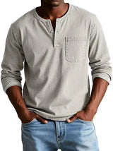 Man wearing a light gray long-sleeve henley shirt and blue jeans on a white background