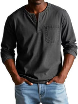 Man wearing a gray long-sleeve henley shirt and blue jeans on a white background