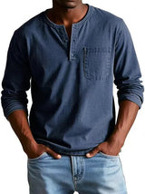 Man wearing a blue long-sleeve henley shirt and jeans on a white background