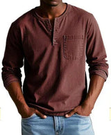 Man wearing a brown long-sleeve shirt with a pocket and light blue jeans on a white background